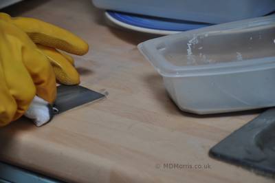 Scrubbing the steel with caustic pumice paste