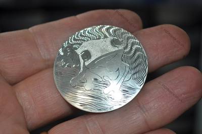 The engraved piece held at an angle to catch the light